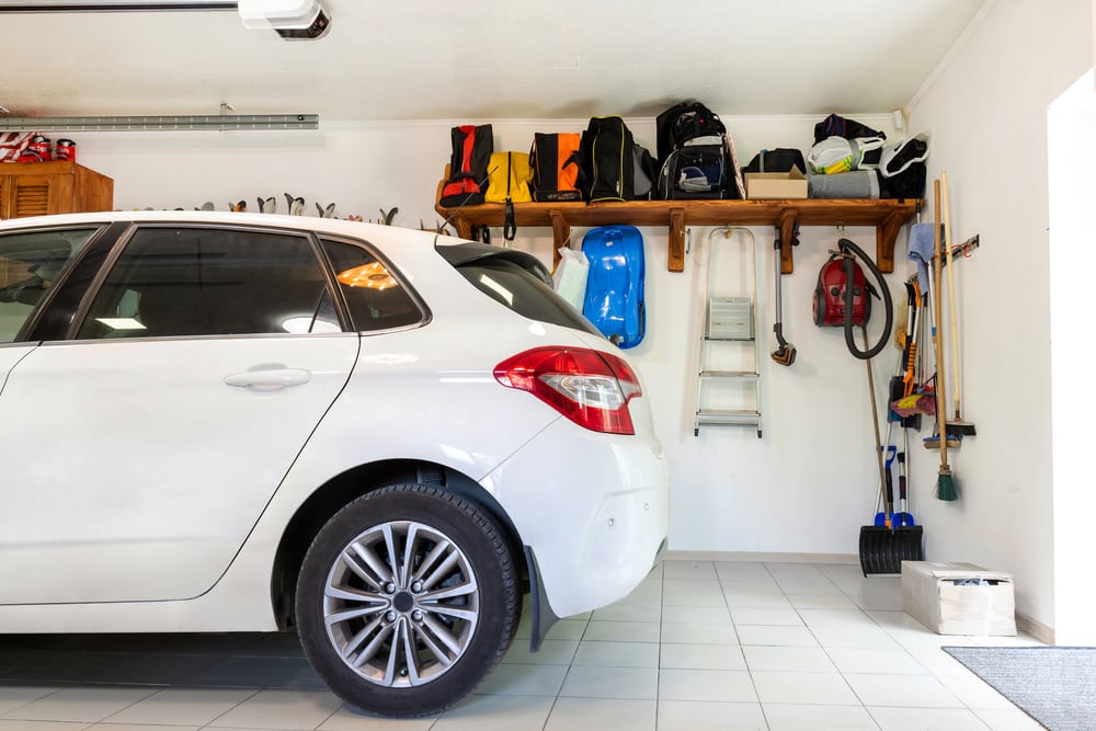 voiture blanche dans un garage maison avec meuble de rangement